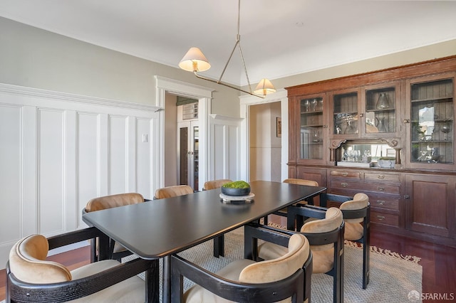 dining space with dark wood finished floors and a decorative wall