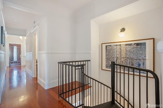 hallway with wood finished floors and an upstairs landing