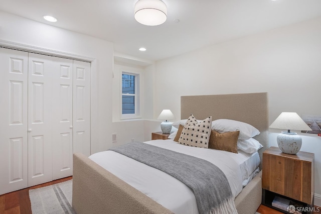 bedroom featuring a closet, wood finished floors, and recessed lighting