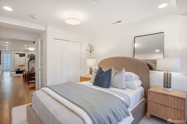 bedroom featuring recessed lighting, a closet, visible vents, and wood finished floors