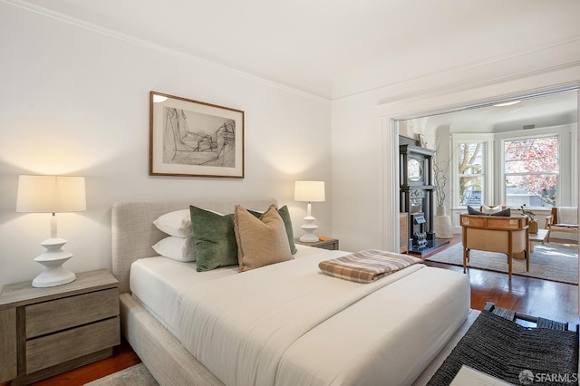 bedroom with wood finished floors and crown molding