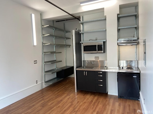 bar featuring sink, dark hardwood / wood-style floors, and stainless steel counters