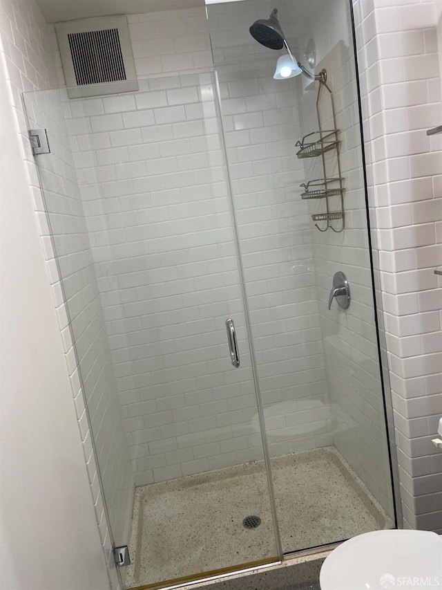 bathroom featuring an enclosed shower and toilet