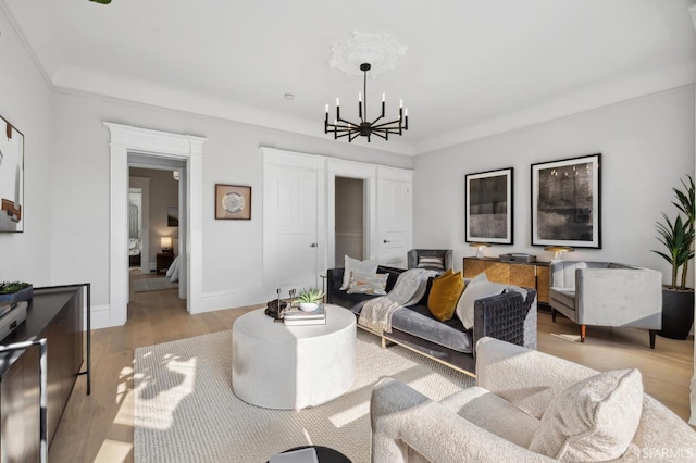 living room with light hardwood / wood-style floors and a notable chandelier