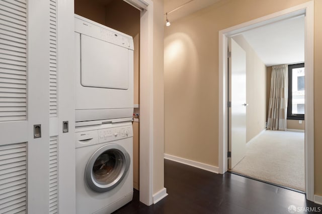 laundry area featuring dark carpet and stacked washing maching and dryer