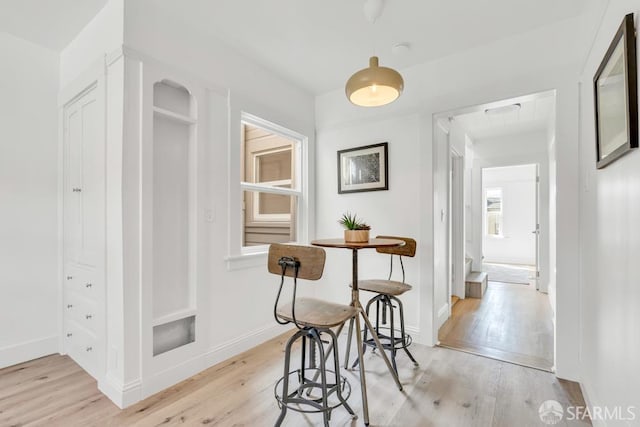 hall featuring light wood-type flooring and baseboards