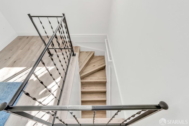 staircase with wood finished floors and baseboards