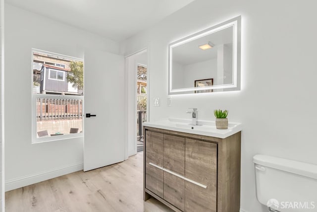 bathroom featuring toilet, vanity, and wood finished floors