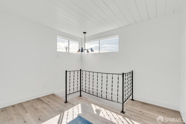 staircase featuring wooden ceiling, wood finished floors, and baseboards