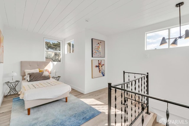 living area featuring an upstairs landing, plenty of natural light, light wood-style flooring, and wooden ceiling