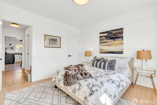 bedroom with baseboards and wood finished floors