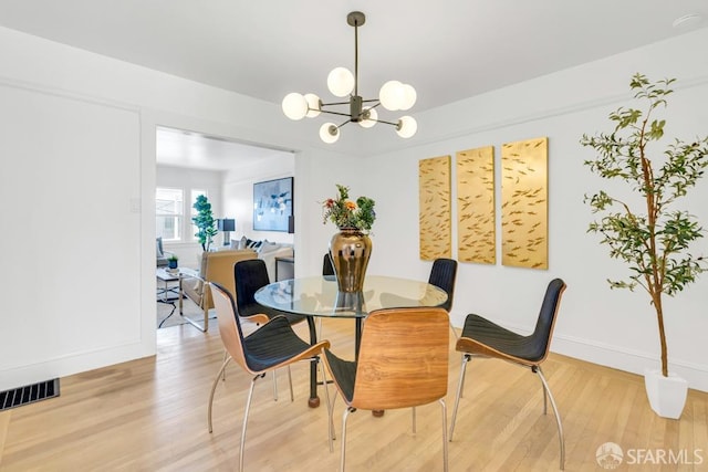 dining room with visible vents, baseboards, an inviting chandelier, and light wood-style flooring