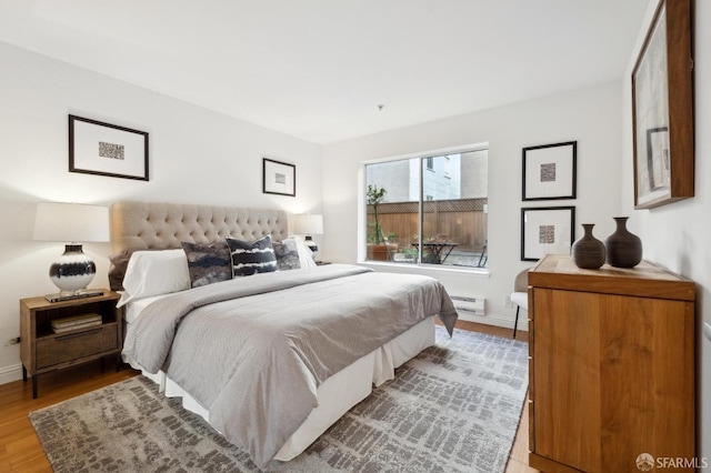 bedroom with light wood finished floors and baseboards