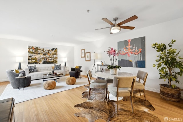 dining area featuring wood finished floors, a ceiling fan, and baseboards