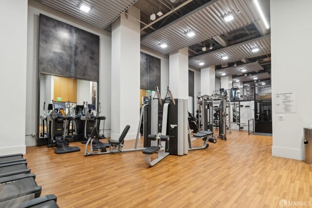 gym with baseboards and wood finished floors