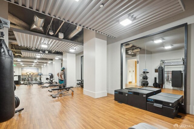 workout area with baseboards and wood finished floors