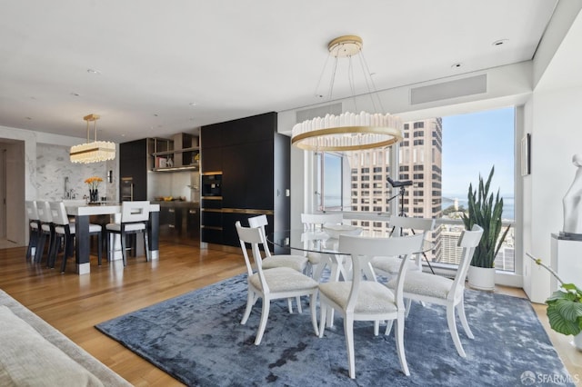 dining area with light wood-style floors and a chandelier