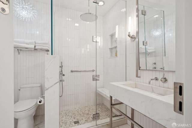 full bath with vanity, a stall shower, toilet, and tile walls