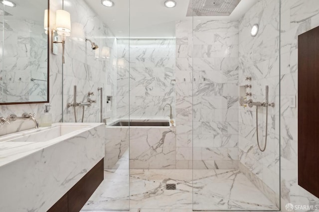 full bathroom with recessed lighting, a tub with marble appearance, a marble finish shower, and vanity