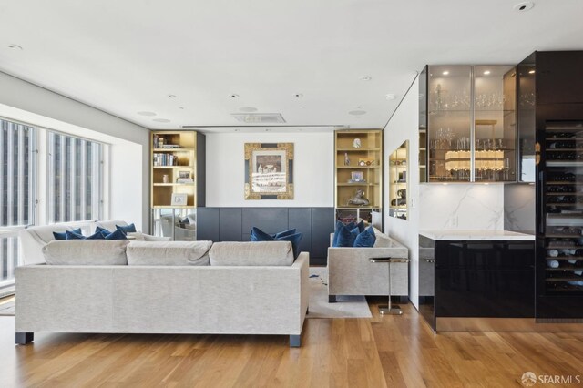 living room featuring light wood-style floors and built in features