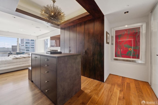 kitchen featuring a kitchen island, open floor plan, light wood-style flooring, and modern cabinets