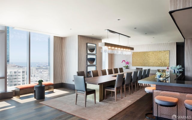 dining space featuring floor to ceiling windows, a chandelier, and wood finished floors