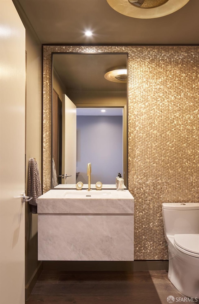 bathroom featuring toilet, wood finished floors, and vanity