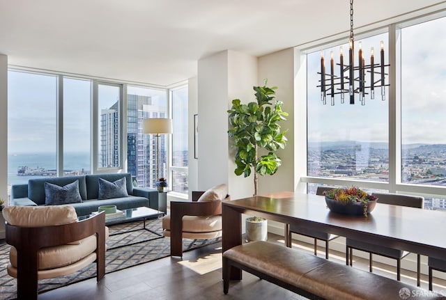 dining area featuring dark wood-style floors, a chandelier, floor to ceiling windows, and a city view