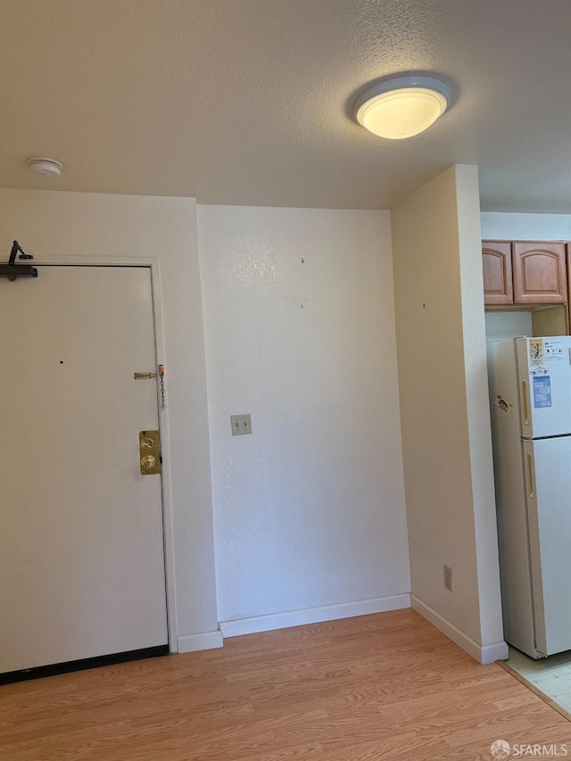 interior space with light hardwood / wood-style flooring and a textured ceiling