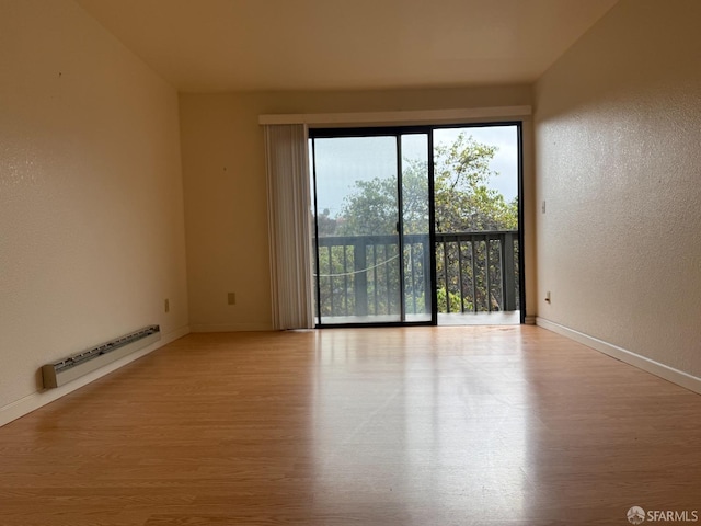 spare room with light wood-type flooring and baseboard heating