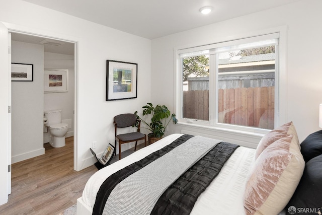 bedroom featuring ensuite bath and light wood-type flooring