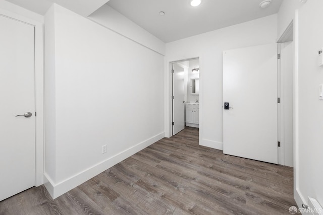 unfurnished bedroom with connected bathroom and light hardwood / wood-style floors