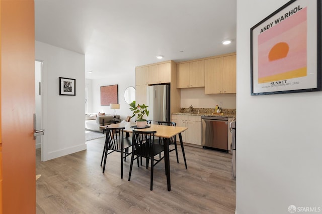 dining room with sink and light hardwood / wood-style flooring