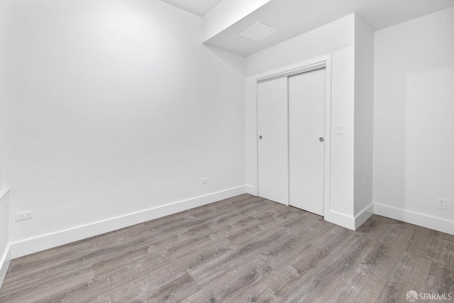 unfurnished bedroom with a closet and light wood-type flooring