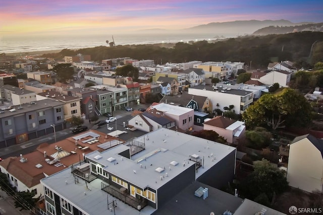 aerial view at dusk featuring a water view