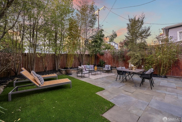 yard at dusk with outdoor lounge area and a patio area