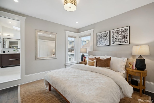 bedroom featuring ensuite bathroom and dark hardwood / wood-style flooring