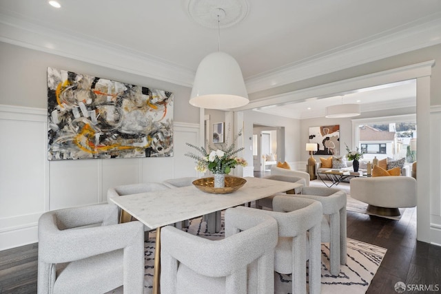 dining room with ornamental molding and dark hardwood / wood-style flooring