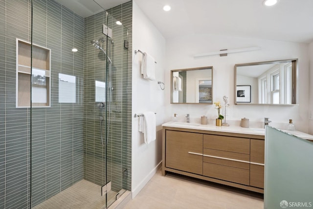 bathroom with lofted ceiling, vanity, a shower with shower door, and tile patterned floors