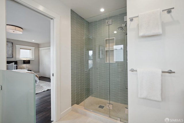 bathroom featuring hardwood / wood-style floors and a shower with shower door