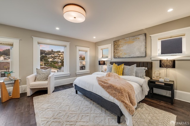 bedroom with multiple windows and dark hardwood / wood-style flooring