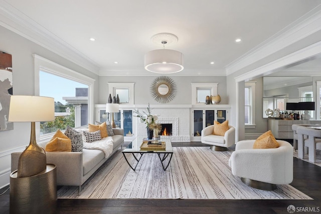 living room with ornamental molding, a brick fireplace, and a wealth of natural light