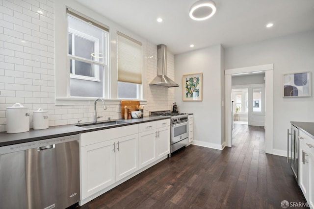 kitchen featuring sink, stainless steel appliances, tasteful backsplash, white cabinets, and wall chimney exhaust hood