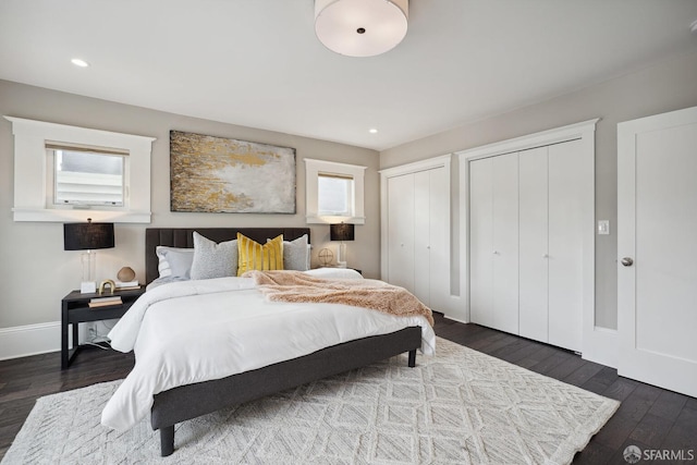 bedroom featuring two closets and dark wood-type flooring