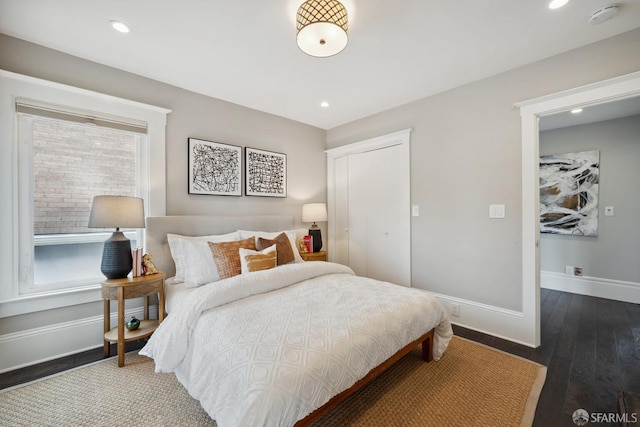 bedroom with dark hardwood / wood-style flooring and a closet