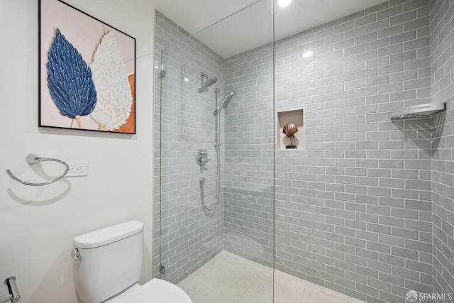 bathroom featuring toilet and a tile shower