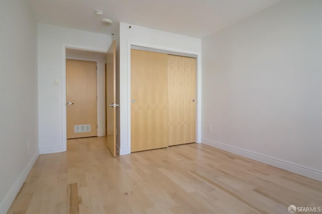 unfurnished bedroom featuring a closet and light hardwood / wood-style flooring