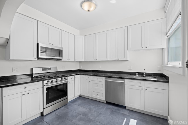 59 Collingwood St, San Francisco, CA 94114 - kitchen with stainless steel appliances, a sink, white cabinets, and dark tile patterned floors