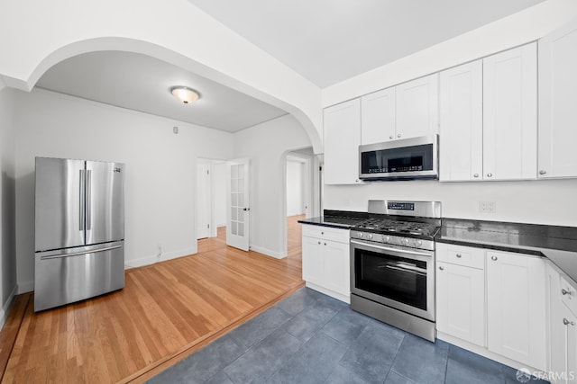 59 Collingwood St, San Francisco, CA 94114 - kitchen with appliances with stainless steel finishes, arched walkways, dark countertops, and white cabinets