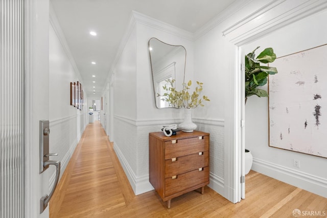 corridor with light wood finished floors, wainscoting, ornamental molding, and recessed lighting